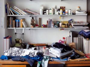 Un angolo di casa nel caos che richiama il bisogno di decluttering e space clearing