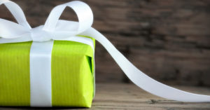 Un pacco regalo verde col nastro bianco