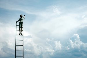 Un ragazzo su una scala per raggiungere il cielo cioè il proprio scopo
