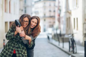 Due sorelle adulte e complici camminano per strada scherzando tra loro