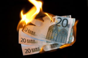 Tre banconote da venti euro che stanno bruciando
