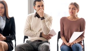 Un uomo dice e non dice qualcosa di sarcastico ad una donna facendosi forte della presenza di altri