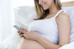 Una mamma incinta tiene lo smartphone troppo vicino al pancione e al nascituro