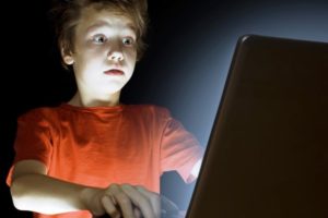Un ragazzino spaventato davanti allo schermo di un pc
