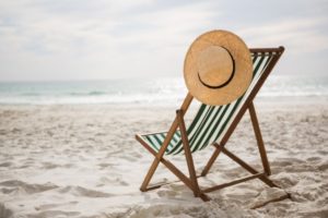 Una spiaggia di sabbia, il mare, una sdradio con un cappello di paglia