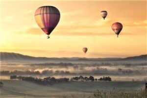 Mongolfiere in cielo e sullo sfondo un'alba rosa
