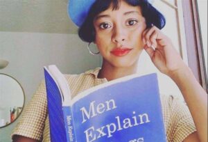 Una ragazza legge il libro "Men explain things to me" di Rebecca Solnit