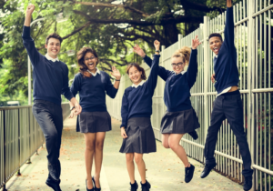 Ragazzi e ragazze felici con la divisa della scuola
